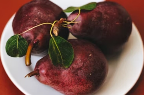 "Close-up image of purple sweet potatoes, one whole and one sliced to reveal their vibrant purple flesh, showcasing their rich color and texture — a perfect example of lesser-known fruits and vegetables.
